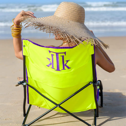 Mujer relajándose en la playa con silla plegable amarilla KTK KONTIKI modelo Bora Bora, ergonómica y portátil, ideal para es-capadas al mar con estilo y comodidad