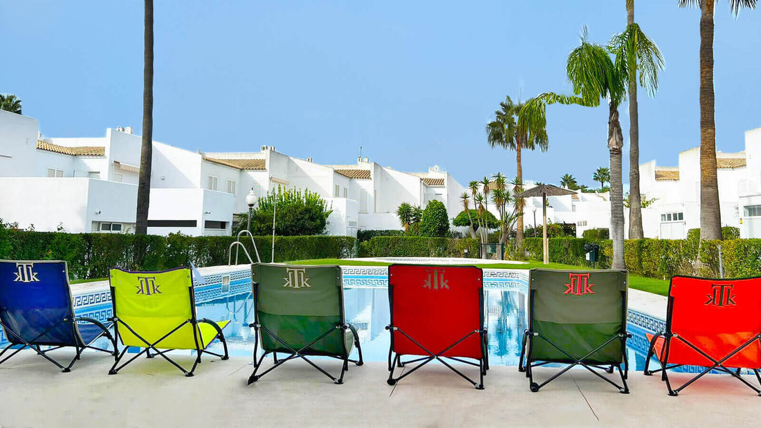 Sillas de playa plegables KTK Kontiki en varios colores junto a piscina en urbanización premium, diseño portátil y ligero para verano 2025.